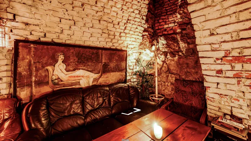 Black Gallery Pub, kadr ze spaceru 360°: obraz nad kanapą i świeca na stoliku